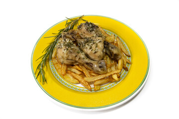 Garlic chicken thighs with French fries, served on a yellow plate, with a sprig of rosemary. Isolated on a white background. Spanish food concept.