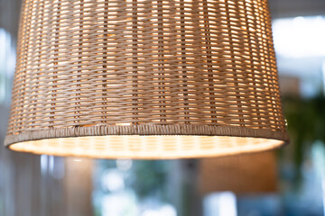 A close-up of the bamboo lantern is glowing. Vintage Thai Woven Bamboo Basket Lamp Beautiful design pendant lamp in dining room