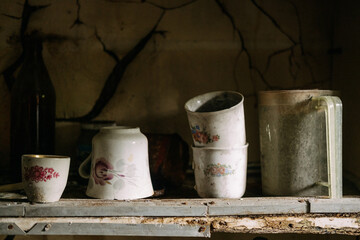 Old dishes in a closet in an abandoned house. Old kitchen. An empty uninhabited house.