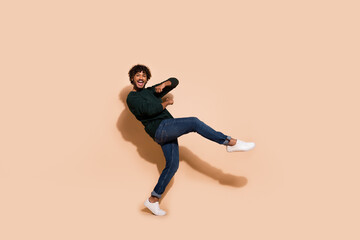 Full size photo of nice young man dancing chilling wear sweater isolated on beige color background