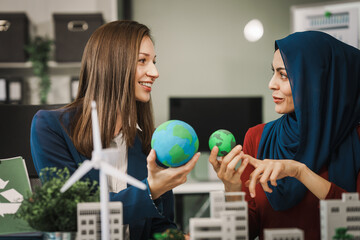 Diverse team, middle-aged Asian businessman, Caucasian young businesswoman, Muslim hijab-wearing...