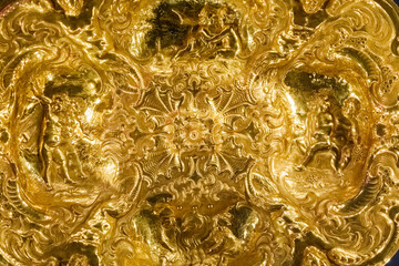 Detail of a pure gold plate, with intricate decorations.