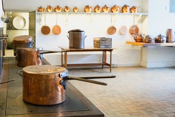 Vintage culinary artifacts and antique cookware are showcased in a historical kitchen exhibition from bygone eras