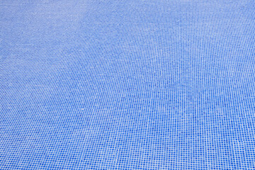 Blue swimming pool without water undergoing repair,