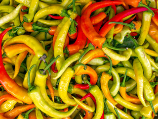 Green and red hot chilli peppers for sale at the local market. Colorful, natural pattern top view...