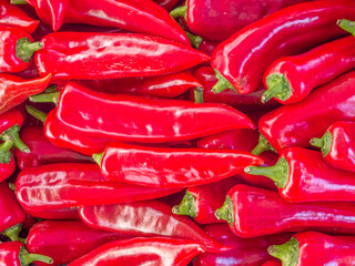 Red hot chilli peppers for sale at the local market. Colorful, natural pattern top view closeup.