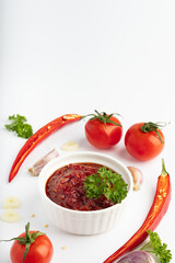 tomato sauce in a bowl adzika isolated on white background