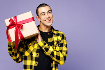 Young smiling middle eastern man wear yellow shirt casual clothes hold present box with gift ribbon...
