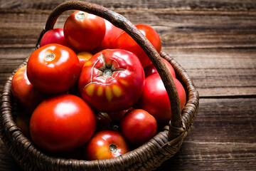 Farmers market with basket of fresh tomatoes on wooden table. Bio tomato harvest.