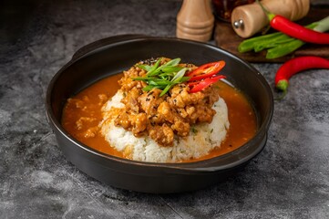 Closeup of rice and meat in a black bowl on a table