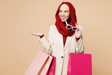 Young Arabian Asian Muslim woman wears red abaya hijab suit clothes shopping hold package bags...