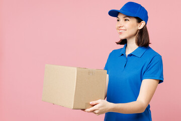 Side view professional delivery girl employee woman wearing blue cap t-shirt uniform workwear work...