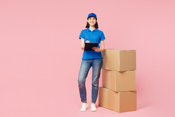 Full body delivery employee woman wear blue cap t-shirt uniform work dealer courier hold clipboard...
