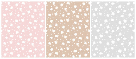 Set of 4 Seamless Patterns with White Stars. Irregular Hand Drawn Simple Starry Print. Infantile Drawing Style Galaxy Design. Little Stars Isolated on a Light Gray, Cappuccino Brown and Pastel Pink.