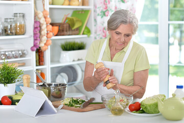 Portrait of a cute senior woman chef portrait at kitchen