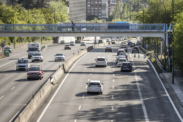 Urban entrance road to Madrid with several lanes in each direction loaded with traffic and...