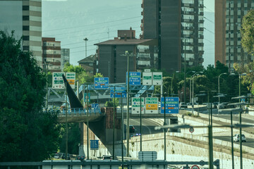 Urban entrance road to Madrid with several lanes in each direction and a multitude of large signs...