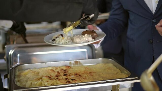 Un comensal se sirve un delicioso plato de comida en un buffet de bodas