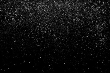 Fototapeta na wymiar Freeze motion of white powder coming down, isolated on black, dark background. Abstract design of falling dust cloud. Particles cloud screen saver, wallpaper with copy space. Rain, snow fall concept