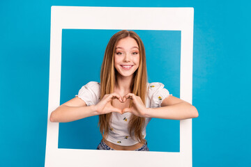 Portrait of lovely young girl album card show heart symbol wear top isolated on blue color...