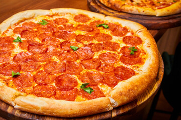 Pepperoni pizza with pepperoni sausage, mozzarella cheese and herbs