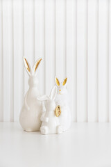 Easter rabbits figurines and eggs on white background. Easter celebration concept. Copy space. Front view - 809834625