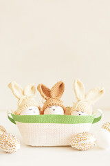 Easter eggs in crochet knitted hats with rabbit ears in nest. Easter celebration concept - 809834695