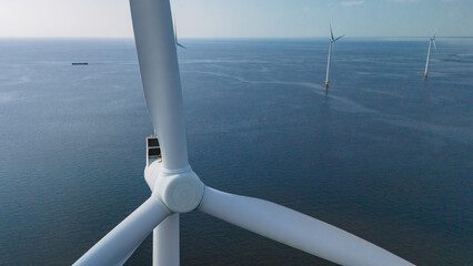 A wind farm with tall windmill turbines standing majestic in the ocean waters, harnessing the...
