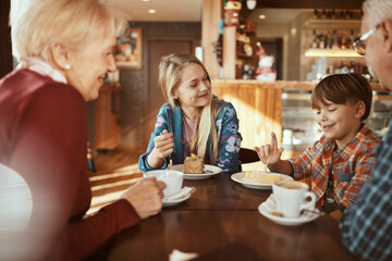 Multigenerational family enjoying dessert together at a cozy Christmas decorated cafe