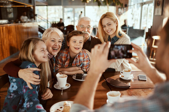 Multi generational family posing for a photo in a Christmas decorated cafe