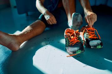 Man taking off dirty shoes at home after workout