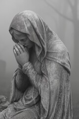 Statue of a woman praying in the cemetery