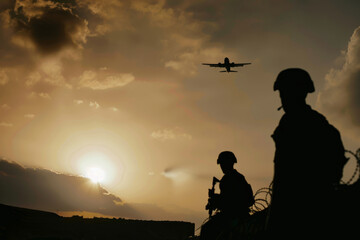 Sunset Silhouettes of Soldiers and Airplane in Flight