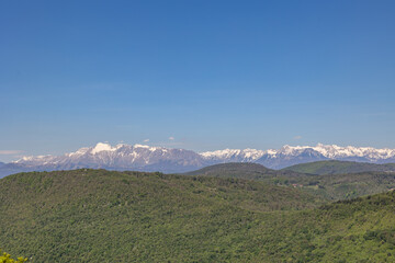 vista dettagliata e dall'alto delle varie catene di colline e montagne tra la Slovenia e l'Italia, viste da lontano, durante una giornata estiva con un cielo sereno