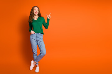 Full length photo of sweet thoughtful lady dressed green shirt showing empty space isolated orange...