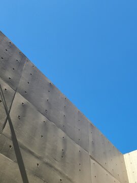 bare cast in place concrete wall with blue sky background in sunny day