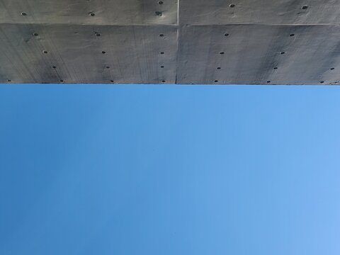 bare cast in place concrete wall with blue sky background in sunny day