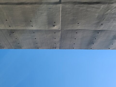 bare cast in place concrete wall with blue sky background in sunny day