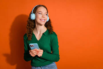 Photo of pretty dreamy lady dressed green shirt earphones enjoying music gadget looking empty space...