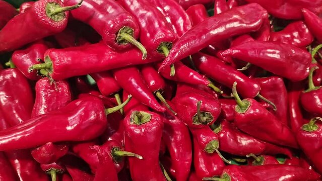 Red pepper in a plastic green box on a market or store counter. Capi red pepper close-up in a supermarket. Selling vegetables