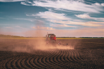 tractor sowing in the dusty field