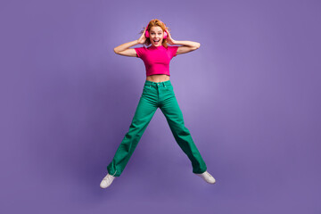 Photo of crazy cheerful nice woman wear stylish pink clothes jump up disco club music isolated on purple color background