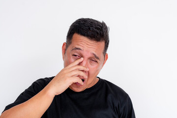 Middle aged Asian man rubbing irritated eyes, isolated on white