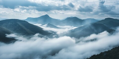 Majestic fog-covered mountain landscape, soothing blues and greens, ideal for quiet contemplation and nature themes, expansive sky overhead.