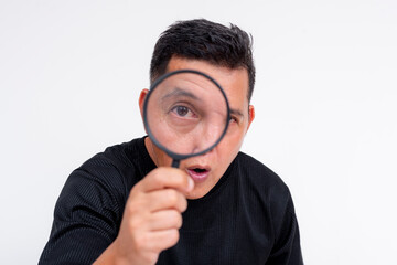 Middle-aged Asian man holding a magnifying glass on a white background