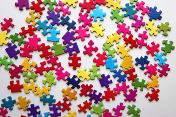 Colorful jigsaw puzzle pieces on white background. Flat lay.