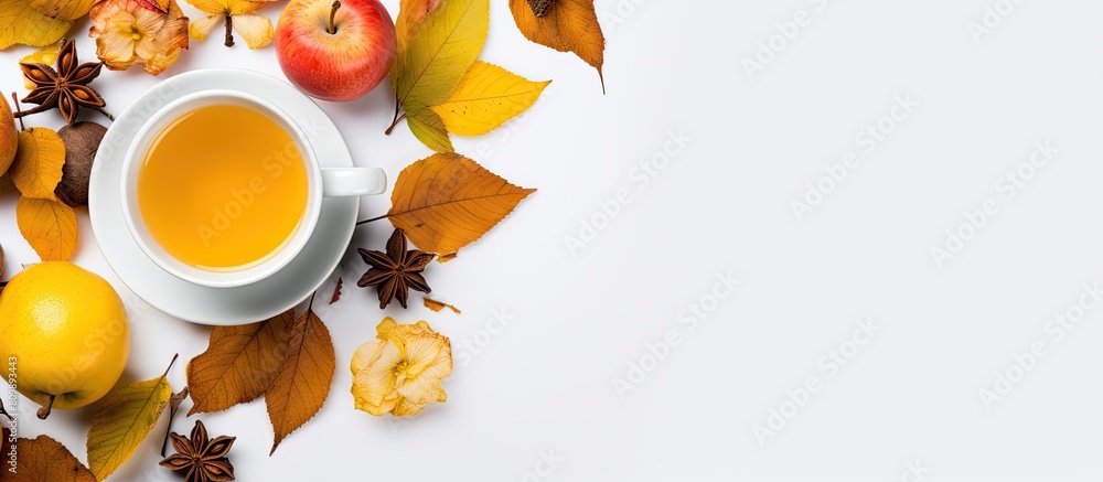 Fototapete Top view of a cup of tea adorned with lemon honey autumn leaves and apples placed on a white background This flat lay image captures the essence of autumn with ample copy space for any desired text