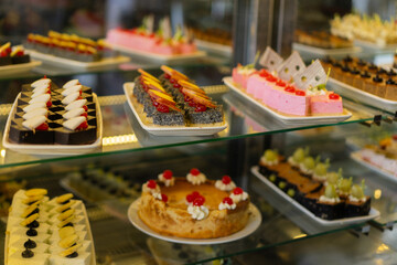Showcase with sweets, Various desserts and cakes for sale in the pastry shop. Glass display at store bakery pastry shop.