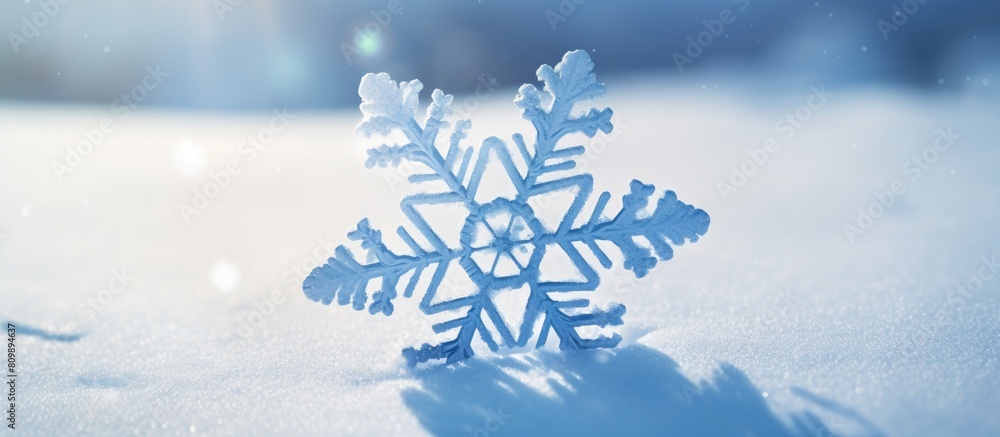 Poster a snowflake with a blue hue stands out against the white snow on a snowy background creating a visua