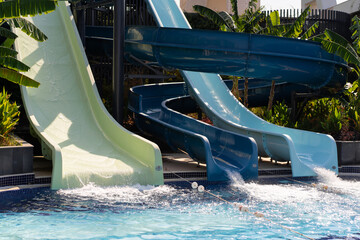 Blue swimming pool with water slide. Summer water slides